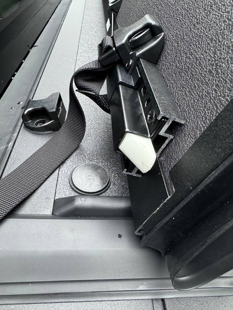 Ford Maverick Newly Ford installed tri-fold rail Tonneau bed cover with weather seal sitting way proud of the surface below, at two cover folds B_Ford_Maverick_2024_hard__tri-fold-Tonneau_bed cover_buckles