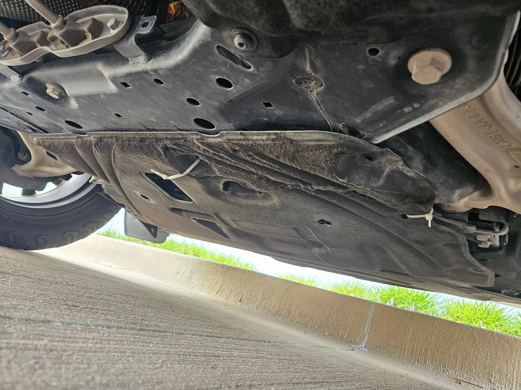 Ford Maverick Loose splash shield flapping and dragging after oil change. 1000003536
